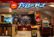 Illuminated Pizza Hut sign on a dark background
