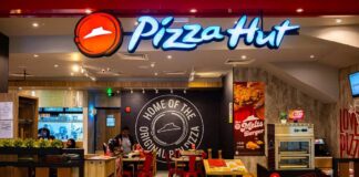Illuminated Pizza Hut sign on a dark background