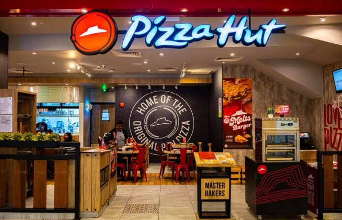 Illuminated Pizza Hut sign on a dark background