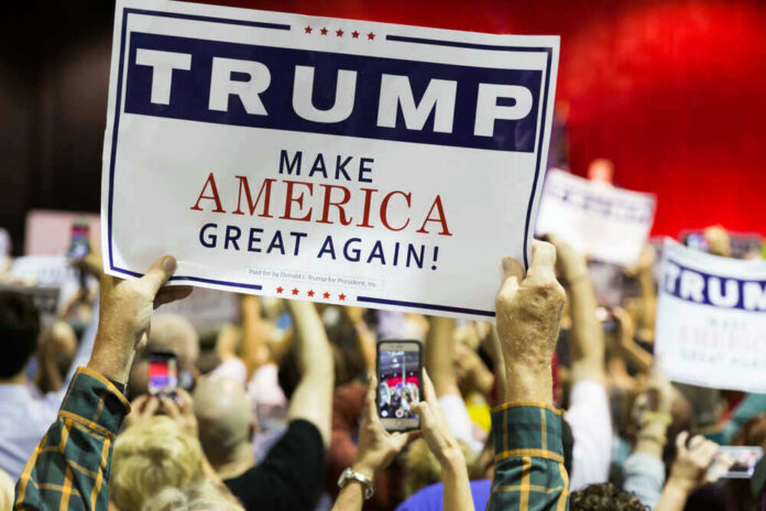 shutterstock_382158925-1 People holding Trump Make America Great Again signs.