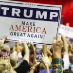 July 4 Hijacked? MAGA Takes The Stage? People holding Trump Make America Great Again signs.