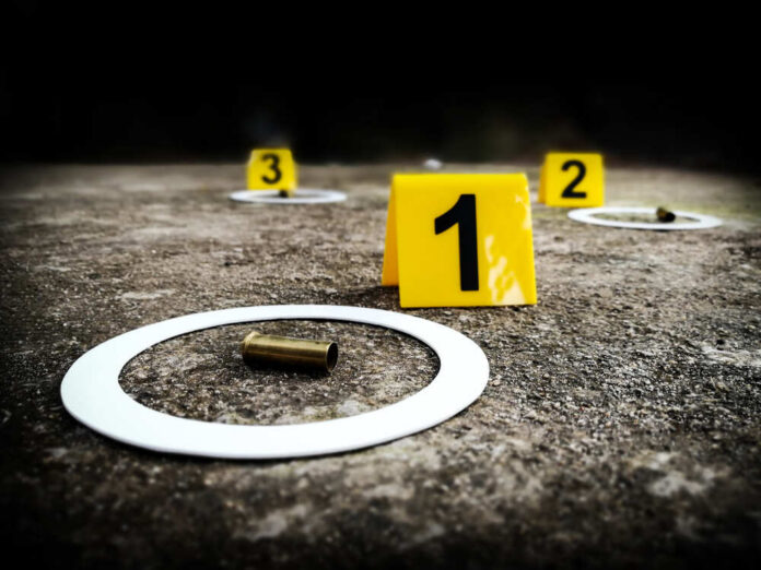 Photograph,Scene,Of,Evidence,Examination Crime scene with evidence markers and a bullet casing on the ground