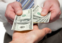 Wage Garnish Wave Incoming Two hands exchanging cash bills