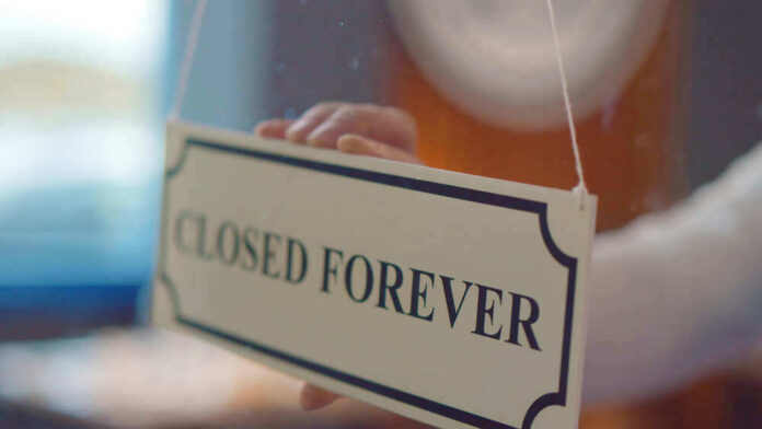 shutterstock_1836658408 Closed forever sign being placed on window.