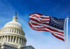U.S. Capitol building with American flag waving.