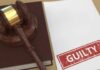Judge’s gavel on a book beside a paper stamped guilty