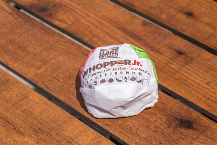 Ostroda,,Poland,-,June,17,,2022:,Burger,King,Whopper,Junior A wrapped Whopper Jr. burger resting on a wooden table