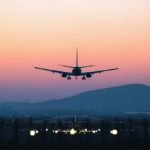 Sick Airline Crew, Sudden Turn Over Atlantic An airplane approaching for landing against a colorful sunset sky