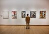 Museum Alarm Fails — Thieves Walk Out Rich A person standing in an art gallery, observing various modern art pieces on the wall