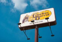 Logo Backlash Topples Cracker Barrel Boss Sign for Cracker Barrel restaurant against a blue sky