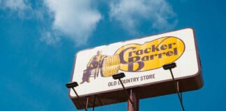 Sign for Cracker Barrel restaurant against a blue sky