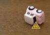 Car Payments Explode — House Money Now? Upside down pink toy car next to a warning sign