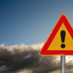 VIDEO: Federal Plaza Firebomb Plot Shocks NYC A triangular warning sign with an exclamation mark against a cloudy sky