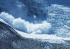 An avalanche cascading down a glacier in a mountainous region