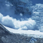 An avalanche cascading down a glacier in a mountainous region