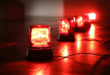 Water Grid Breached — 12 States Rattled Red emergency lights on dark floor, illuminating the area.