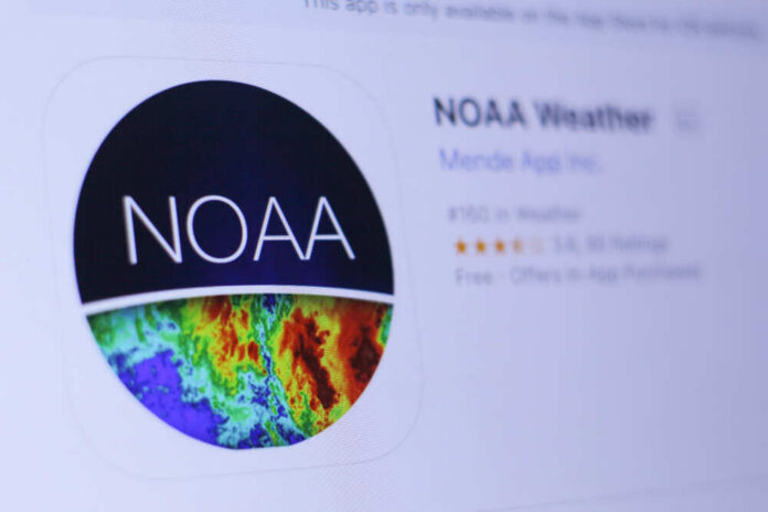 Jember,,East,Java,,Indonesia,,June,23,,2018.,Noaa,Weather,App Thermometer displaying high temperature against a bright sun