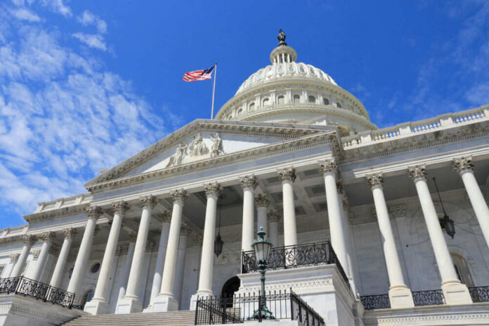 shutterstock_1122138182 US Capitol building with American flag and columns