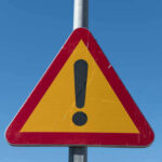 VIDEO: Gold Pit Turns Mass Grave Triangular warning sign with exclamation mark.
