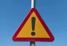 VIDEO: Gold Pit Turns Mass Grave Triangular warning sign with exclamation mark.
