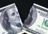 A torn hundred dollar bill featuring Benjamin Franklin
