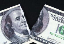 A torn hundred dollar bill featuring Benjamin Franklin