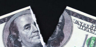 A torn hundred dollar bill featuring Benjamin Franklin