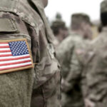 Pentagon Purge Sparks Censorship Outcry U.S. soldiers in camouflage uniforms with American flag patch.