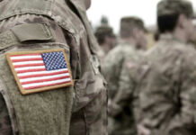 Pentagon Purge Sparks Censorship Outcry U.S. soldiers in camouflage uniforms with American flag patch.
