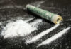 Cocaine lines with rolled banknote on surface
