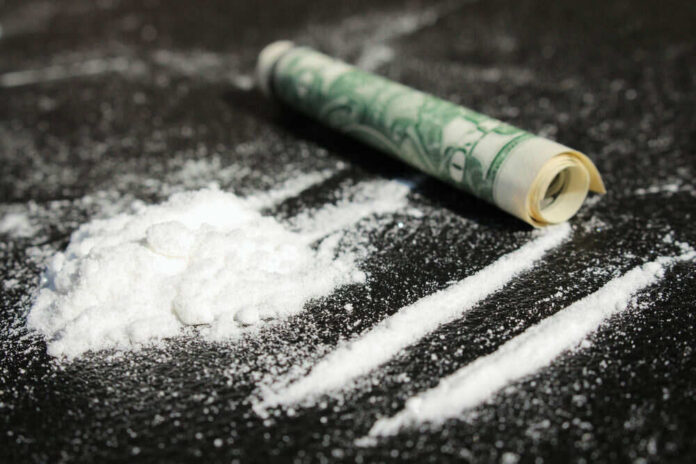 shutterstock_217852807 Cocaine lines with rolled banknote on surface