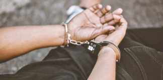 Person in handcuffs with hands behind back.