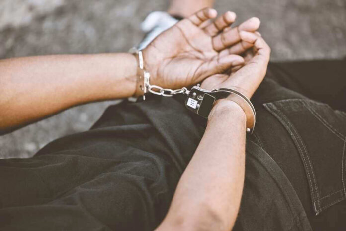 Person in handcuffs with hands behind back.