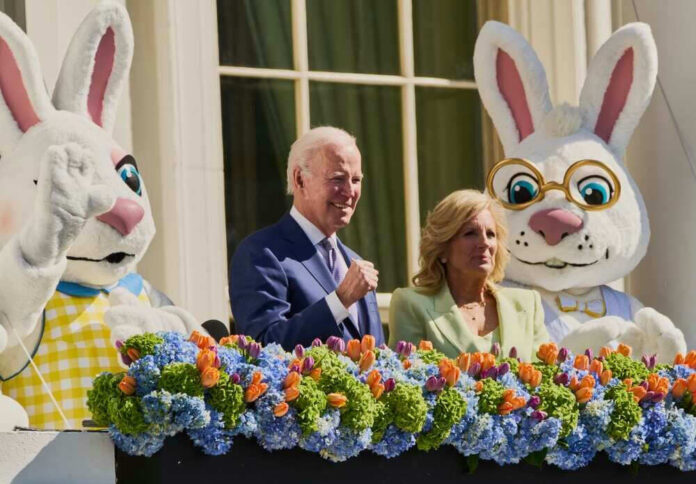 shutterstock_2296015991 Joe and Jill Biden with Easter Bunny costumes and flower decoration.