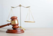 Prosecutors Push Back: High-Stakes Reversal A wooden gavel in front of a balance scale symbolizing justice