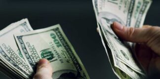 Hands holding and counting stacks of cash