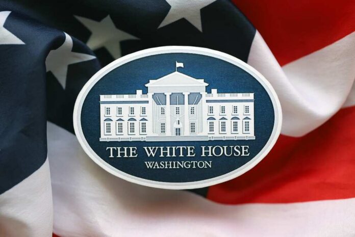 Press podium with the White House sign and an American flag in the background