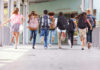 Measles Threat Creeps Into Classrooms Children running with backpacks outside a school building.