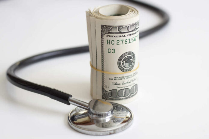 A,Stack,Of,Dollars,And,A,Stethoscope,Health,Insurance,Future Medical staff walking through a hospital corridor