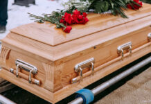 Wooden casket with red roses on top