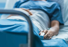 Veteran’s Hospital Nightmare Exposed A patient lying in a hospital bed with a monitoring device in hand