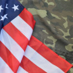 286 Days At Sea — Finally Relief? American flag draped over camouflage fabric
