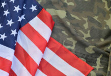 American flag draped over camouflage fabric