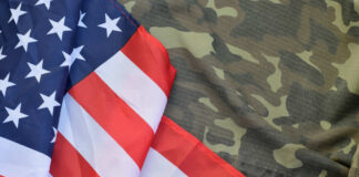 American flag draped over camouflage fabric