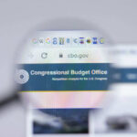 Congress Locks Clocks — Health Bombshell Looms? Magnifying glass over Congressional Budget Office website