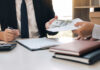 Two individuals engaged in a business transaction involving money and documents