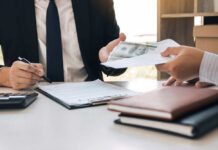 401(k) Shock: Record Smashes Expectations Two individuals engaged in a business transaction involving money and documents