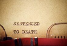 First Woman Execution In 200 Years For THIS State Typewriter typing the phrase 'Sentenced to Death' on aged paper