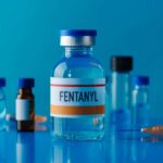 A vial labeled Fentanyl surrounded by various medical containers and a syringe
