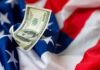 Trump’s $5,000 Tease Ignites Trillion-Dollar Questions A hundred dollar bill resting on an American flag